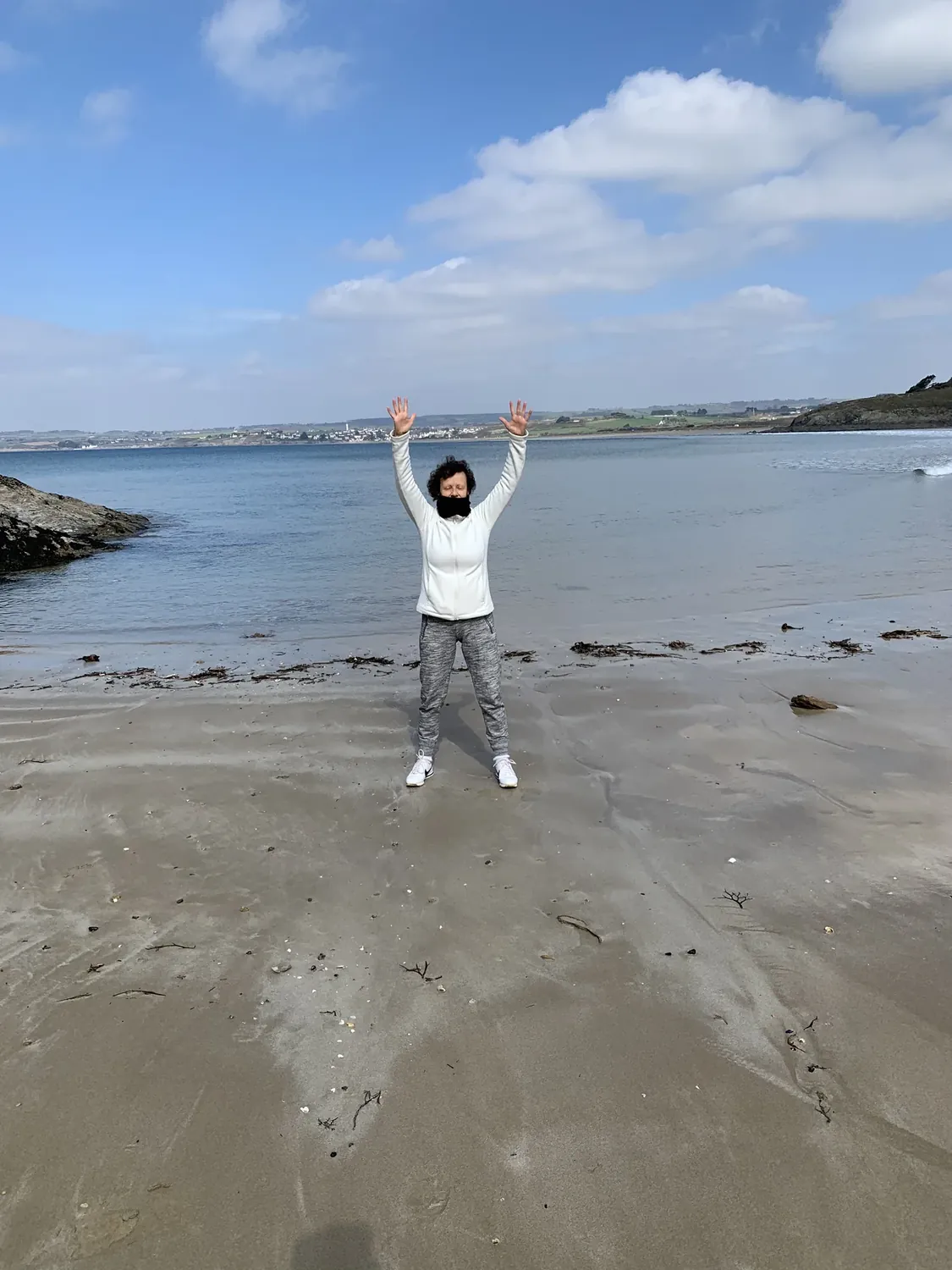 Sylvie Gonidec les bras levés sur une plage bretonne